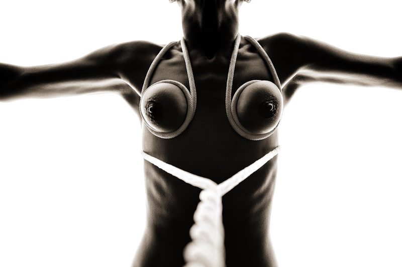 Eine nackte Frau mit gefesselten abgebundenen Brüsten Bondage BDSM schwarzweiß erotische Photographie